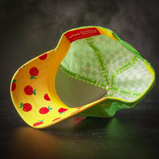 Inside view of green and yellow linen trucker cap hat with apples printed on the underbrim