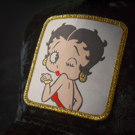 Close-up of a woven patch of Betty Boop blowing a kiss attached to the trucker cap crown.