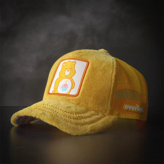 Yellow faux fur trucker cap hat featuring Birthday Bear from Care Bears on woven patch attached to crown
