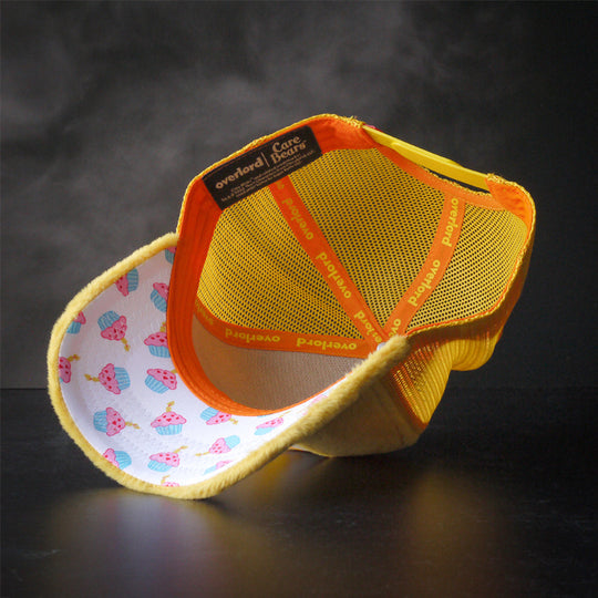 Yellow faux fur trucker cap hat with cupcakes printed on the underbrim