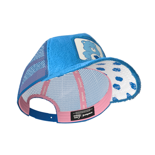 Blue faux fur trucker cap with blue mesh featuring a woven patch of Grumpy Bear from Care Bears attached to the crown.