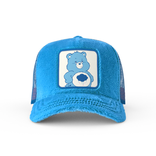 Blue faux fur trucker cap with blue mesh featuring a woven patch of Grumpy Bear from Care Bears attached to the crown.