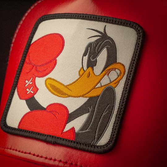 Close-up of Looney Tunes Boxing Daffy Duck woven patch on red faux leather trucker cap hat