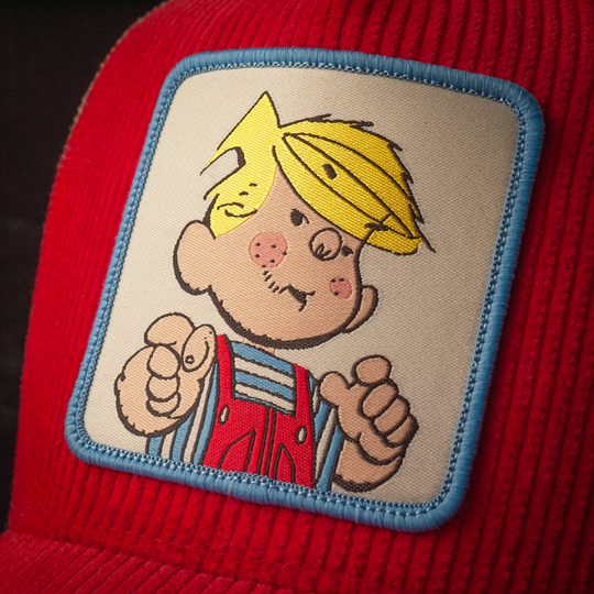 Close-up of Dennis the Menace woven patch on red corduroy trucker cap hat
