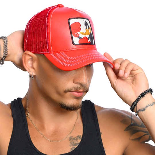 Man wearing red faux leather trucker cap hat with Looney Tunes Boxing Daffy Duck woven patch against a white background
