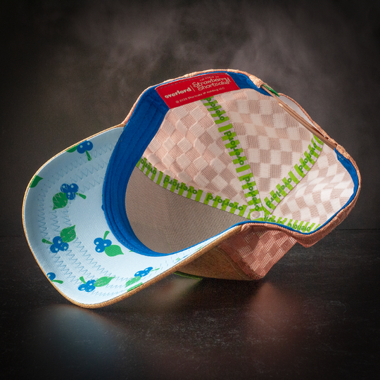 Inside view of brown linen trucker cap hat with huckleberries printed on underbrim