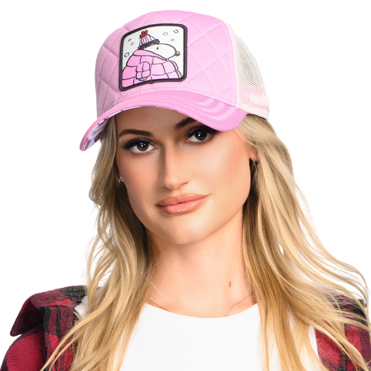Woman wearing quilted pink trucker cap hat with Peanuts Snoopy in pink jacket woven patch against a white background