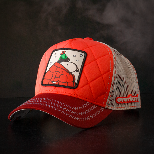 Quilted red trucker cap hat with Peanuts Snoopy in red jacket woven patch against a black background