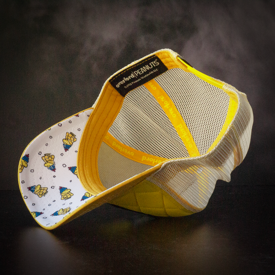 Inside view of quilted yellow trucker cap hat with Woodstock in a jacket fabric print underbrim.