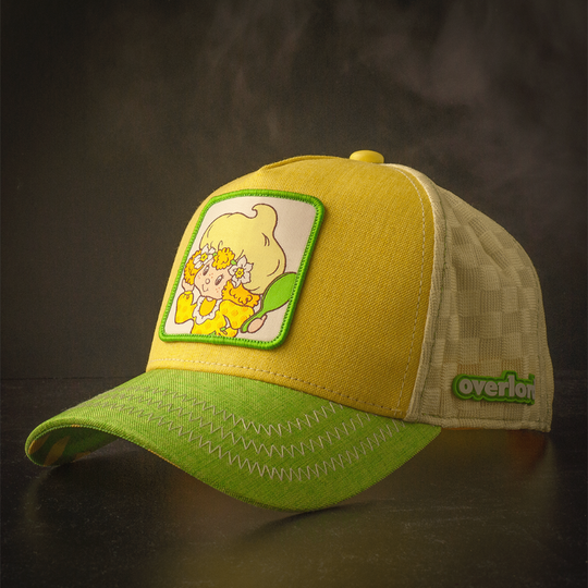 Yellow and green linen trucker cap hat with Lemon Meringue from Strawberry Shortcake on woven patch against a black background