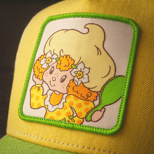 Close-up of Lemon Meringue from Strawberry Shortcake on woven patch on yellow linen trucker cap hat