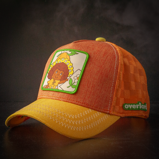 Orange and yellow linen trucker cap hat with Orange Blossom from Strawberry Shortcake on woven patch against a black background