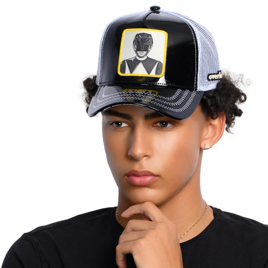Man wearing shiny black  faux leather trucker cap featuring a Power Rangers Black Ranger woven patch on crown.
