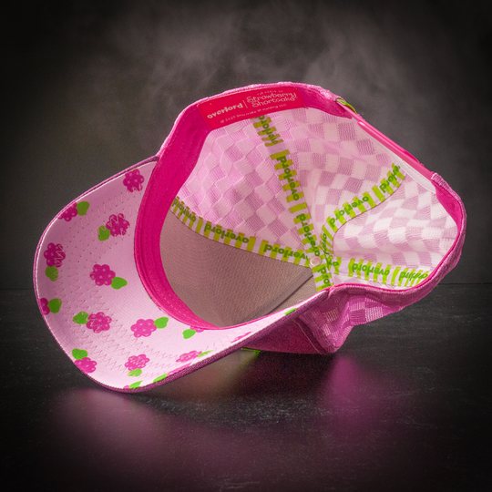 Inside view of magenta linen trucker cap hat with raspberries printed on the underbrim