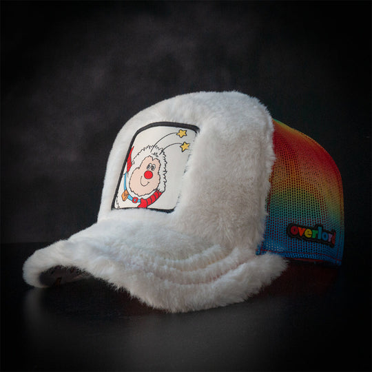 White faux fur trucker cap hat with rainbow mesh featuring Twink from Rainbow Brite on woven patch attached to crown against black background