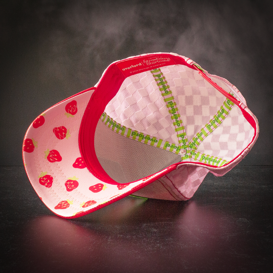 Inside view of red and pink linen trucker cap hat with red strawberries printed on the underbrim