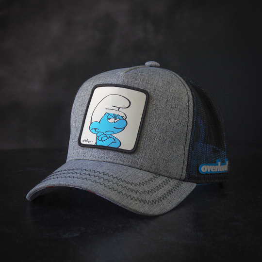 Heather gray trucker cap with black mesh featuring a woven patch of Grouchy Smurf from the Smurfs attached to crown