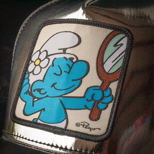 Close up of Vanity Surf woven patch on a metallic silver trucker cap