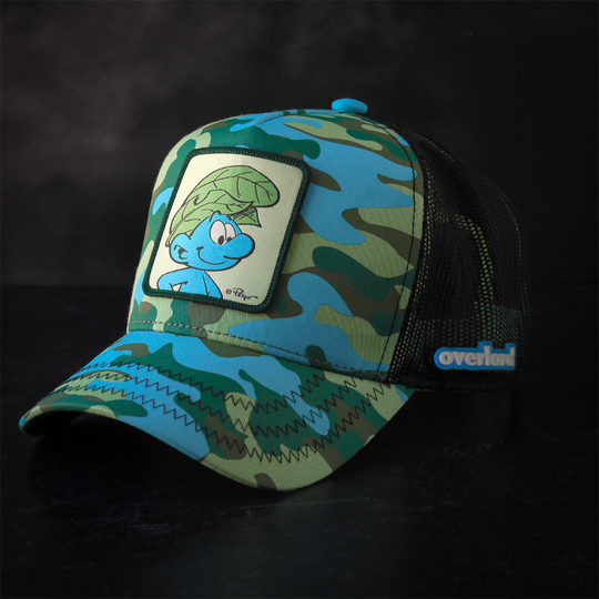 Turquoise and green camo trucker cap with black mesh featuring a woven patch of Wild Smurf from the Smurfs attached to the crown
