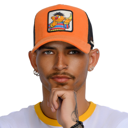 Man wearing orange fleece trucker cap hat with Sesame Street Ernie woven patch against a white background