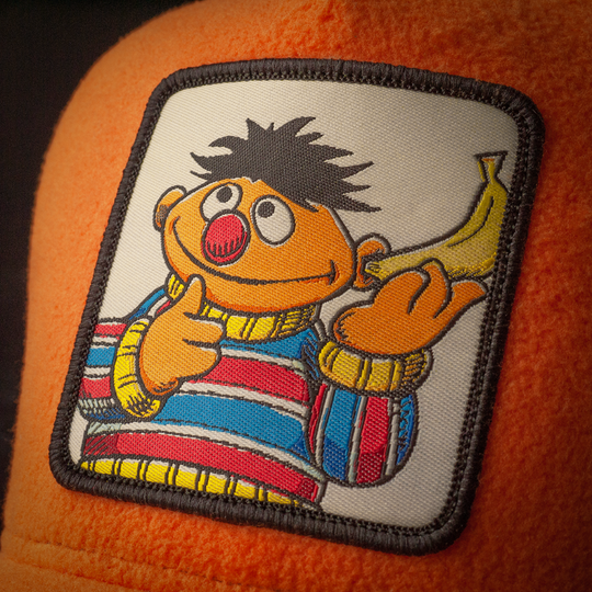 Close-up of Sesame Street Ernie woven patch on orange fleece trucker cap hat