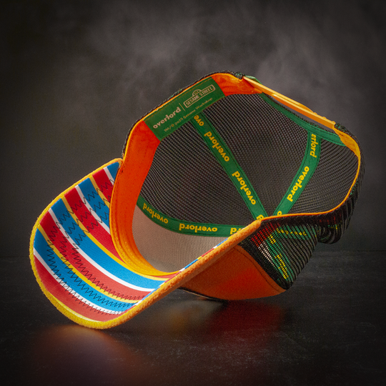 Inside view of orange fleece trucker cap hat with striped printed fabric underbrim
