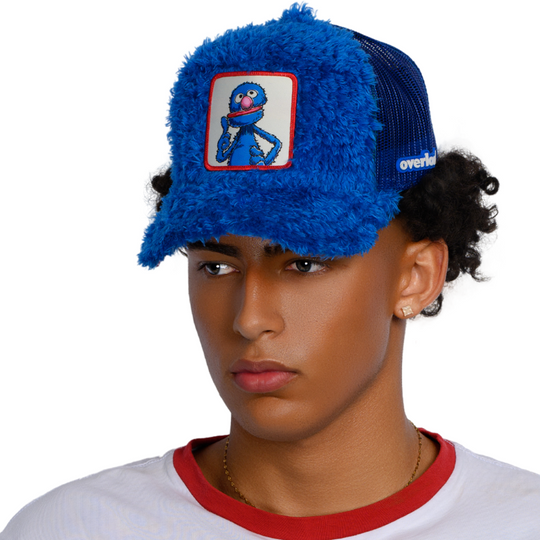 Man wearing blue faux fur trucker cap hat featuring Grover from Sesame Street on woven patch attached to crown