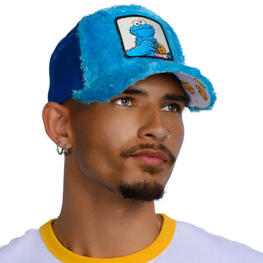 Man wearing turquoise faux fur trucker cap hat featuring Cookie Monster from Sesame Street on woven patch attached to crown