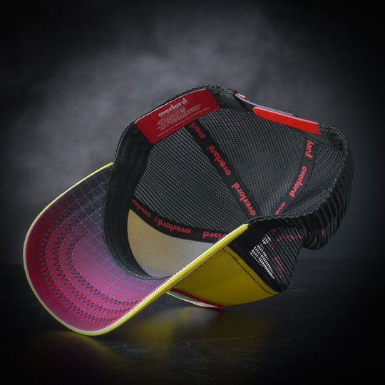 Inside view of yellow trucker cap hat with red and black gradient grid printed on underbrim
