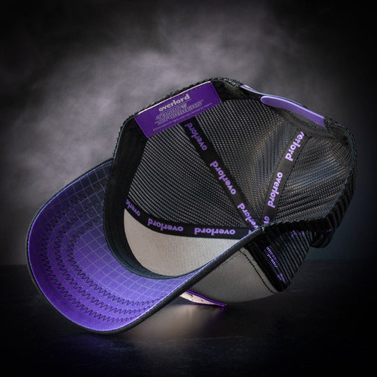 Inside view of gray and black trucker cap hat with black and purple gradient grid printed on underbrim