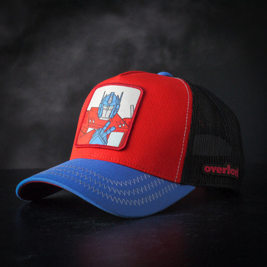Red and blue trucker cap hat featuring Optimus Prime from Transformers on woven patch attached to crown