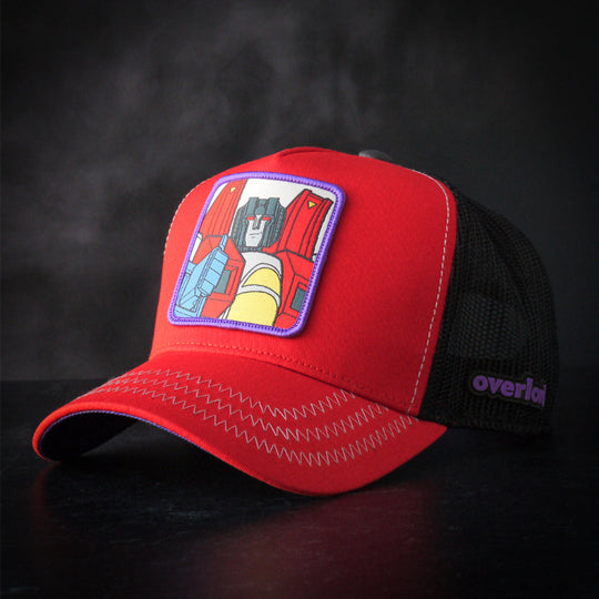 Red trucker cap hat featuring Starscream from Transformers on woven patch attached to crown