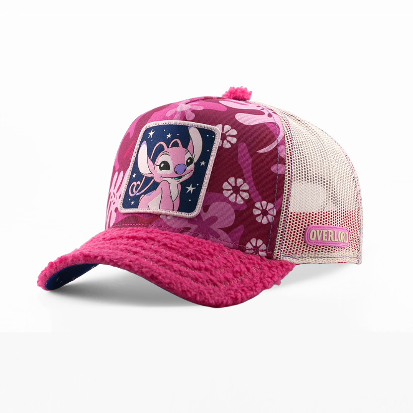 A pink and magenta trucker hat featuring a floral pattern on the front panel, a patch of the character Angel, and a fleece-lined curved brim, shown on a white background.