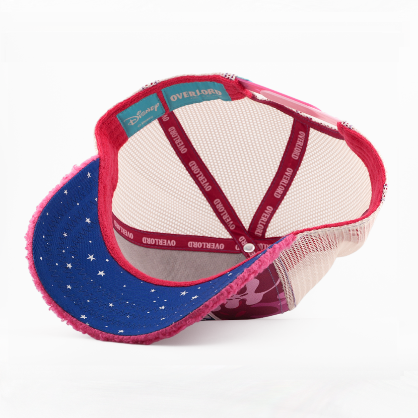 A Disney-themed trucker cap shown from a rear-three-quarter angle on a white background. The cap features a blue visor with white stars, a pink fuzzy trim, a beige mesh back, and red straps with 'OVERLOAD' printed on them.