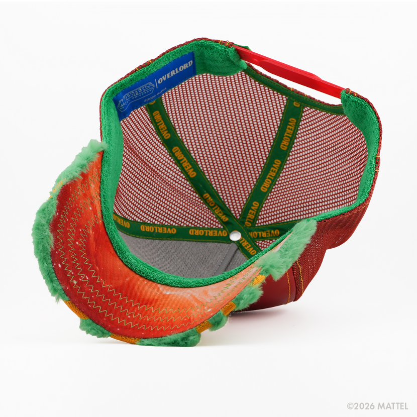 Underside of the Battle Cat from Masters of the Universe retro trucker cap, showing an orange starry-print brim, blue Masters of the Universe tag, red mesh crown, and green Overlord branded taping with gold text.