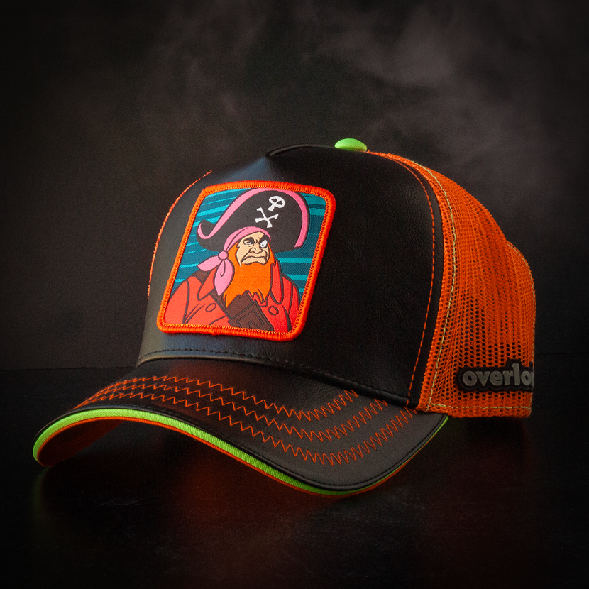 Black faux leather trucker cap with orange mesh featuring a woven patch of Red Beard villain from Scooby Doo attached to the crown.