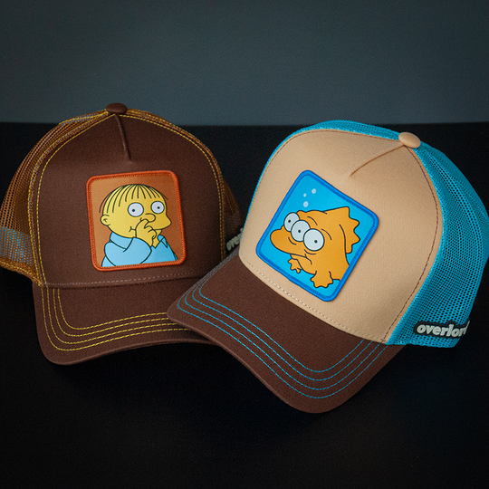 Brown OVERLORD X The Simpsons Ralph Wiggum picking his nose trucker baseball cap hat with yellow stitching. PVC Overlord logo.