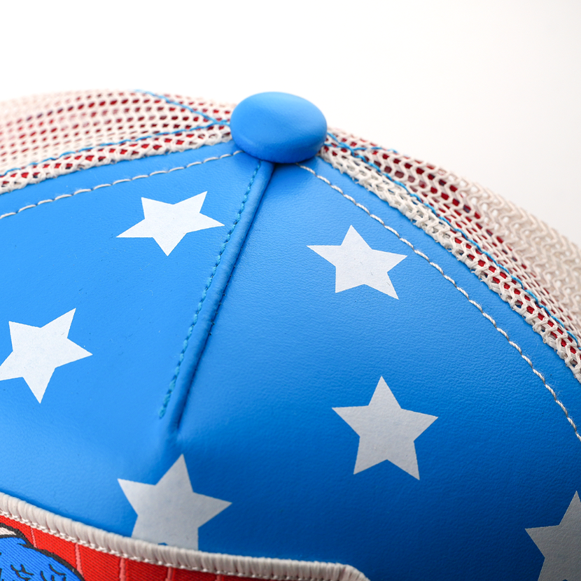 Close-up of the star-print blue crown and button top on the Captain America cap, with white mesh side panel.