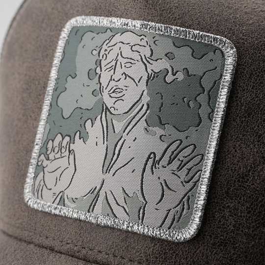 Close-up of the Han Solo in Carbonite from Star Wars patch, stitched onto the gray suede-texture trucker cap fabric with silver border.