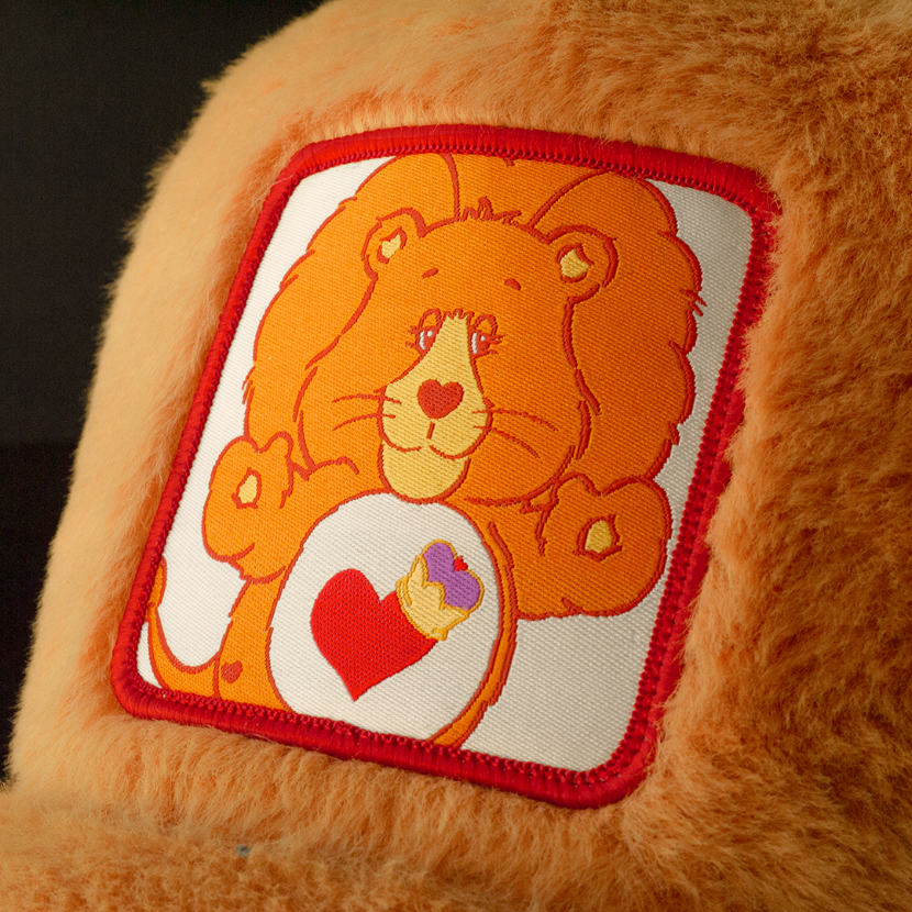 Close up of Braveheart Lion woven patch on orange plush trucker cap hat.