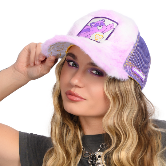 Woman wearing purple and white tie dyed faux fur trucker cap hat featuring Bright Heart Racoon from Care Bears on woven patch attached to crown