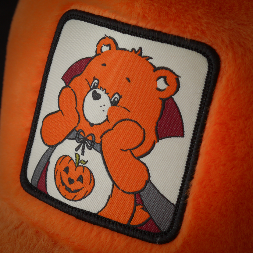 Close-up of Trick or Sweet Bear from Care Bears on woven patch attached to trucker cap crown