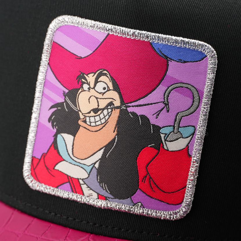 Close-up of a woven patch showing Captain Hook from Disney's Peter Pan grinning with his hook raised on a purple background, stitched onto black fabric with a silver glitter-textured border.