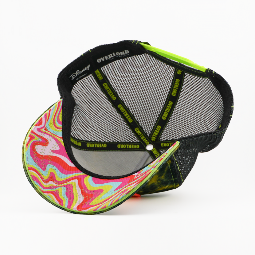 Underside of the Caterpillar from Disney's Alice in Wonderland retro trucker cap showing a swirled, weathered-texture brim in pink, yellow, and blue, a Disney tag, black mesh crown, and black Overlord branded taping with neon-green text.