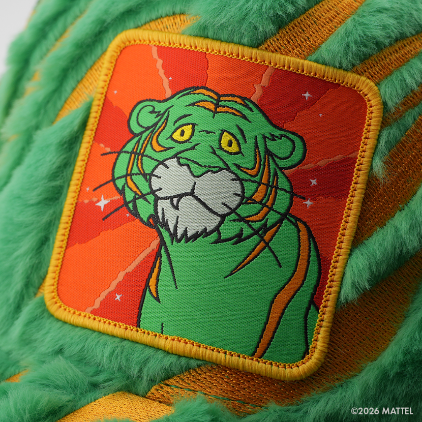 Woven patch of Cringer from Masters of the Universe with a tiger-striped face and yellow eyes, set against an orange starry background with gold border, stitched onto the green fuzzy-textured retro trucker cap.