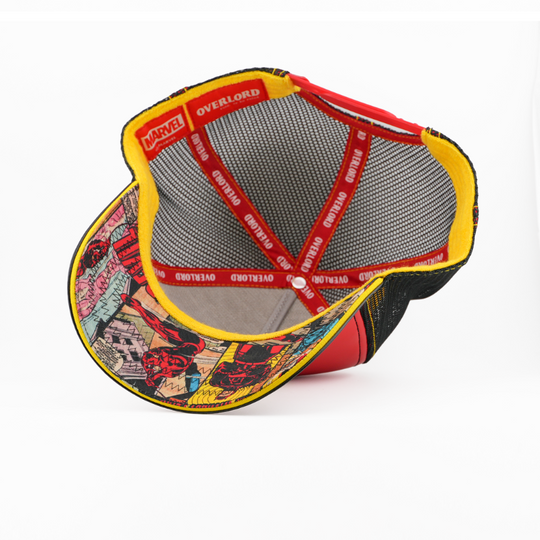 Underside view of the Daredevil cap showing a comic-print brim, black mesh crown, and red Overlord branded taping.