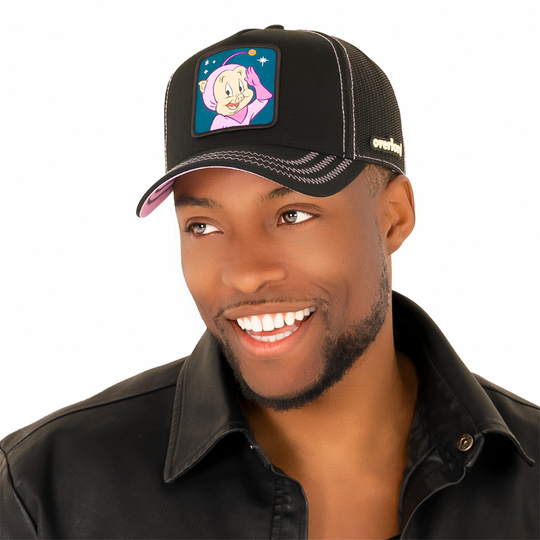 Man wearing black twill trucker cap with black mesh featuring a woven patch of Porky Pig as the Space Cadet attached to the crown.
