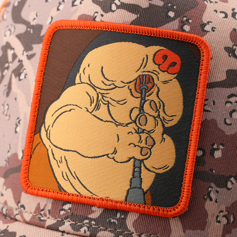 Close-up of the Droopy McCool from Star Wars patch playing his instrument, stitched onto the camo-print trucker cap fabric with orange border.