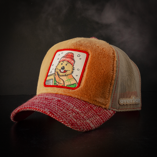 Caramel brown faux fur trucker cap with red and white heathered sweater knit brim and khaki mesh featuring a woven patch of Harvey the Beaver from Emmet Otter attached to the crown.