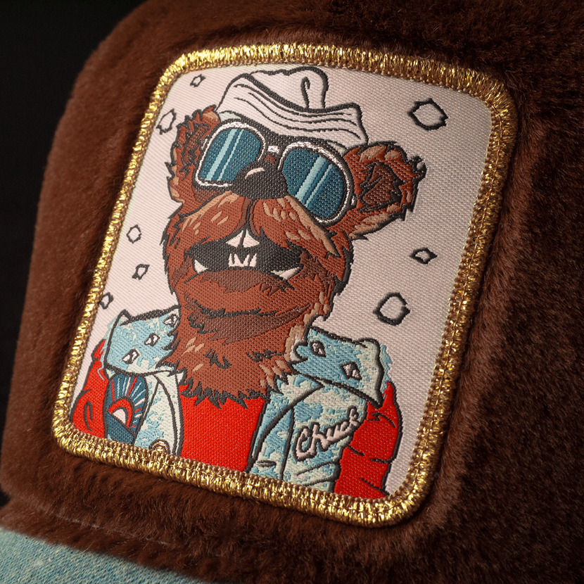Close up of a woven patch of Chuck the Stoat from Emmet Otter attached to the crown.